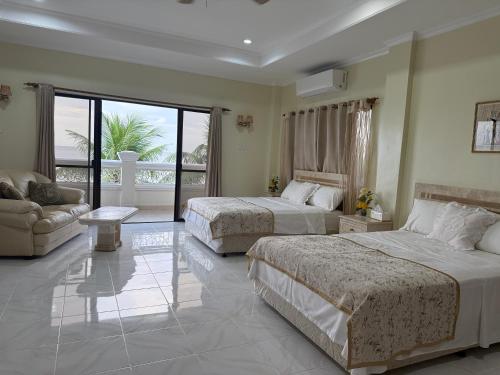 ein Hotelzimmer mit zwei Betten und einer Couch in der Unterkunft Mateos Villa in Carmen