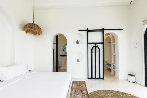 a bedroom with white walls and a bed and a rug at 5BR Ocen View Villa in Jimbaran in Jimbaran