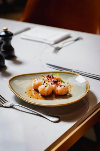 a plate of food sitting on a table at Threadneedles, Autograph Collection in London