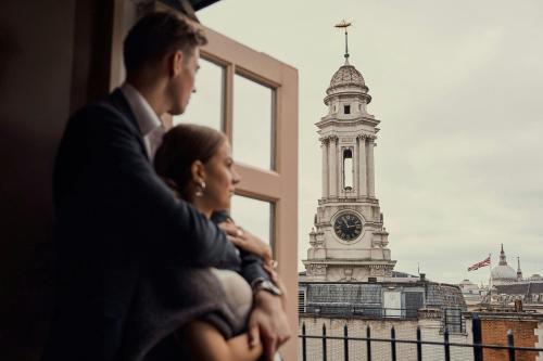 Ein Mann und eine Frau betrachten einen Glockenturm in der Unterkunft Threadneedles, Autograph Collection in London
