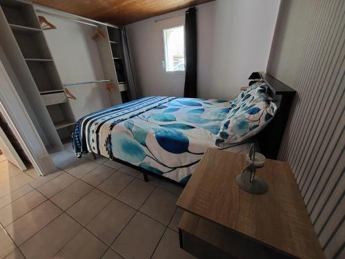 a small bedroom with a bed and a table at Gîte Orléo Sérénité in Saint-Vincent-Rive-dʼOlt