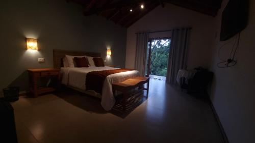 a bedroom with a bed and a sliding glass door at Doce Refugio in Santo Antônio do Pinhal