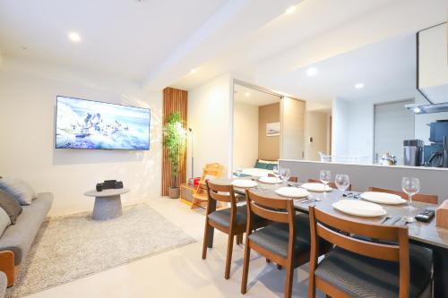 a dining room and living room with a table and chairs at Urna Sands Hotel in Tokyo