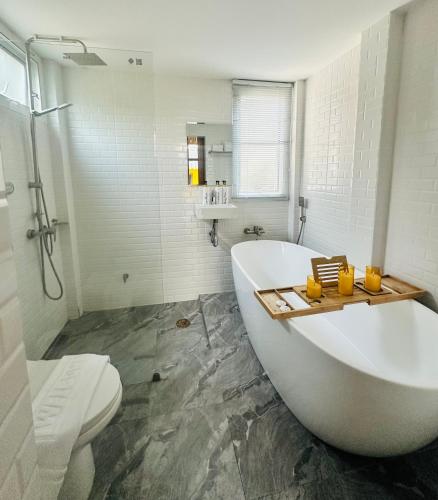a white bathroom with a tub and a toilet at Pai Cheese cottage in Pai