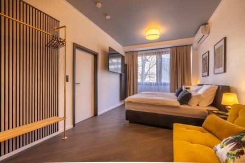 a bedroom with a bed and a yellow couch at Family Apartment History 5 Gäste Air Condition Parken Frei in Munich