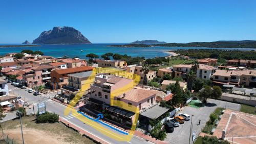an aerial view of a town with a yellow building at Guesthouse La Locanda - Comfy Rooms & Local Food in Porto San Paolo