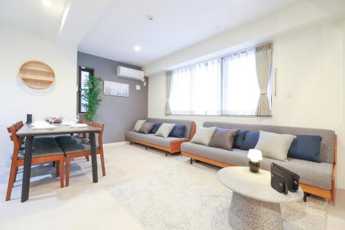 a living room with a couch and a table at Urna Sands Hotel in Tokyo