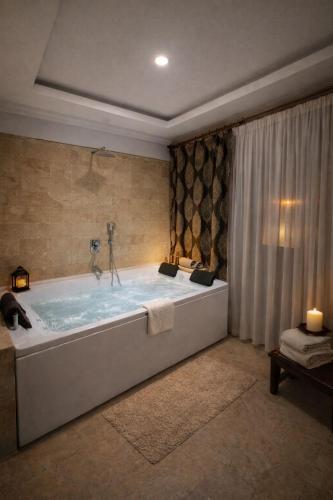 a large bath tub in a bathroom with a window at Whitestone Hotel in Nevşehir
