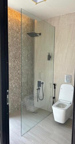 a bathroom with a toilet and a glass shower at Malath Farm in Al Rahba