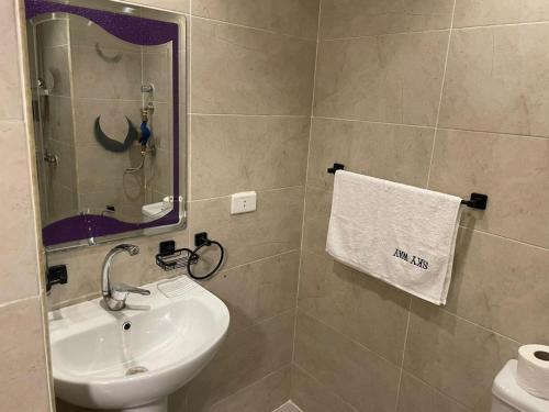 a bathroom with a sink and a mirror and a towel at Florenza Resort- Hurghada in Hurghada