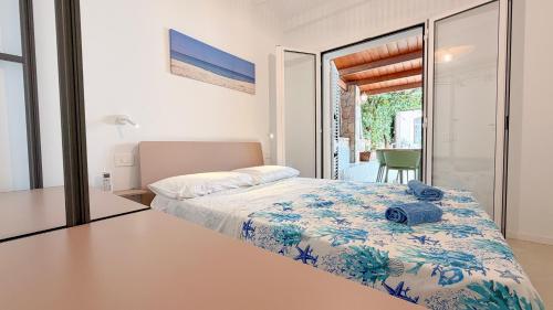 a bedroom with a bed and a table and a view at Cefalù Beach Garden House in Cefalù