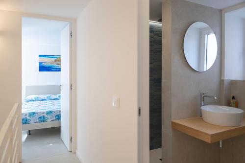 a bathroom with a sink and a mirror at Cefalù Beach Garden House in Cefalù