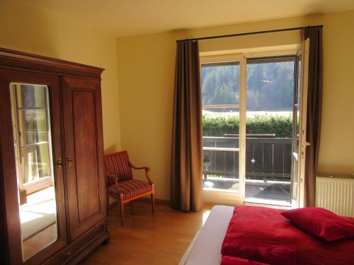 a bedroom with a bed and a window and a chair at Ferienwohnung Alpenvilla in Bischofswiesen