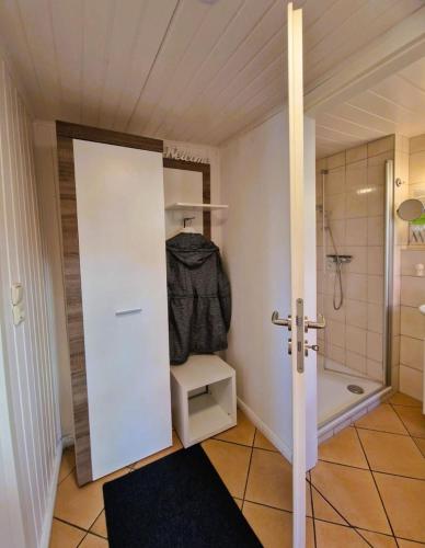 a bathroom with a shower and a white door at Haegerende _Alte Liebe_ in Groß Kirr
