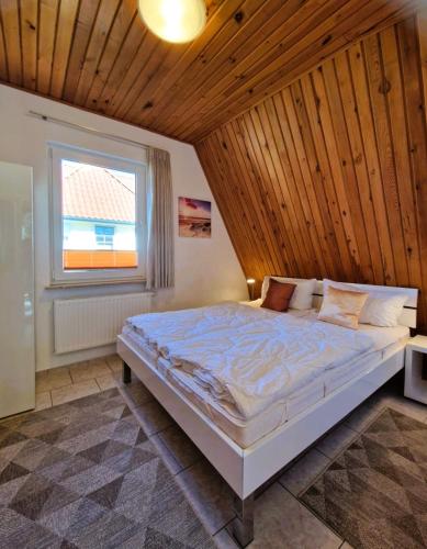 a bedroom with a large bed with a wooden ceiling at Haegerende _Seitensprung_ in Groß Kirr
