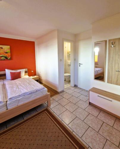 a bedroom with a bed with an orange wall at Haegerende _Seitensprung_ in Groß Kirr