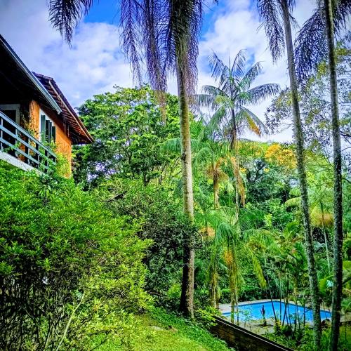 a resort with a swimming pool in the middle of trees at Refúgio Pasárgada Guest House in Mairiporã
