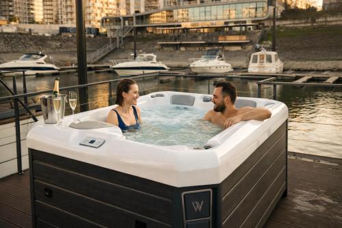 a man and a woman in a jacuzzi tub at Prestige Yacht Resort Budapest in Budapest