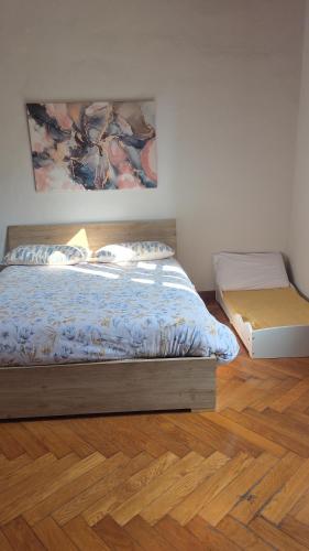 a bedroom with a bed and a painting on the wall at Casa Del Teatro in Pavia