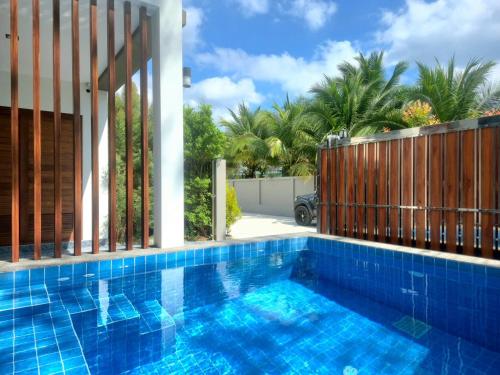 a swimming pool with a wooden fence and a blue swimming pool at Bestest Pool Villa in Krabi