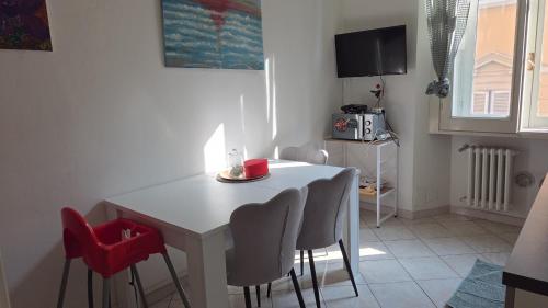 a dining room with a white table and chairs at Casa Del Teatro in Pavia