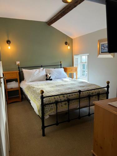 a bedroom with a bed with a teddy bear on it at The Ivy House in Chalfont Saint Giles