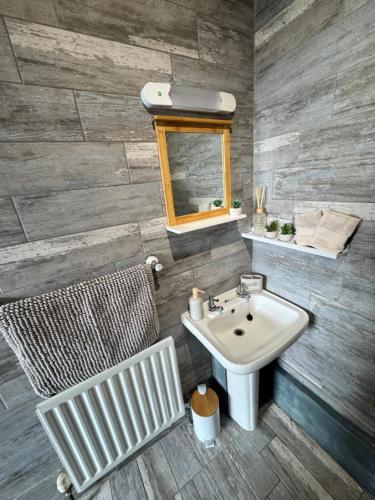 a bathroom with a sink and a mirror and a chair at Craven Heifer in Skipton