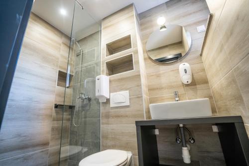 a bathroom with a toilet and a glass shower at Sobe Biser Dunava - smještaj uz Dunav in Vukovar