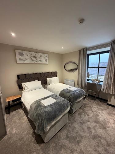 a hotel room with two beds and a window at Craven Heifer in Skipton