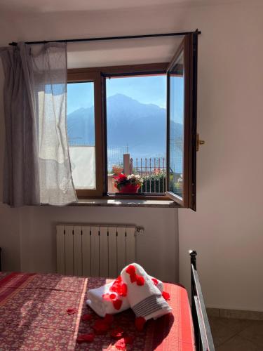 a bedroom with a bed and a window with a view at Casetta al Belvedere - Lake View in Vercana