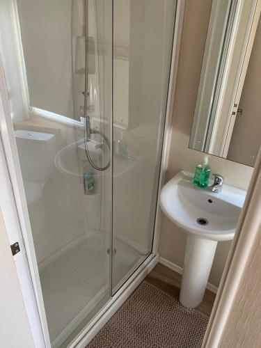 a bathroom with a shower and a sink at A&L Holiday Home Craigtara in Ayr