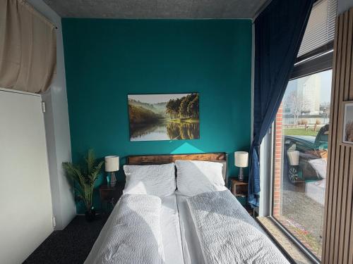 a bedroom with a large bed with a blue wall at Wohnglück Alte Werft Leer in Leerort