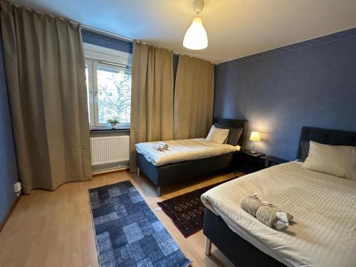 a small room with two beds and a window at Noah Longstay Bygatan in Västerås