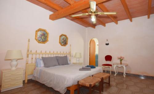 ein Schlafzimmer mit Bett und Deckenventilator in der Unterkunft Can Bril in Campos