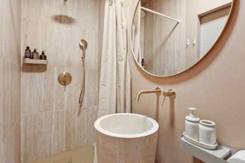 a bathroom with a sink and a shower with a mirror at French house in Paris