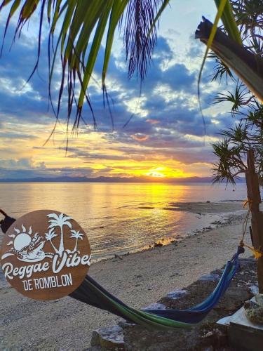a hammock on a beach with a sunset at Green Sea Turtle in Romblon