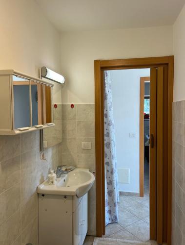 a bathroom with a sink and a mirror and a door at Casetta al Belvedere - Lake View in Vercana