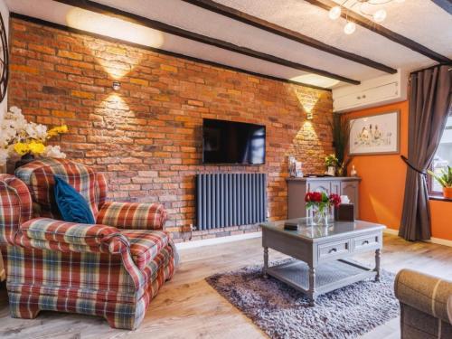 a living room with a brick wall at Y Bwythyn - Lovely cottage in village of Spittal in Haverfordwest