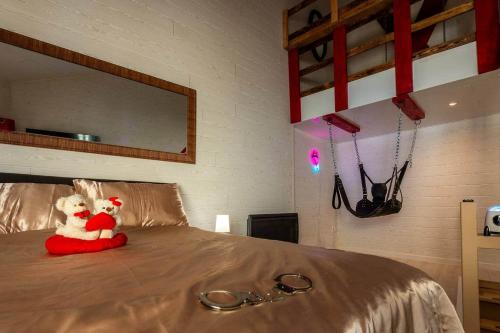 a stuffed animal sitting on top of a bed at love escape "Love Room" in Saint-Paul-Trois-Châteaux