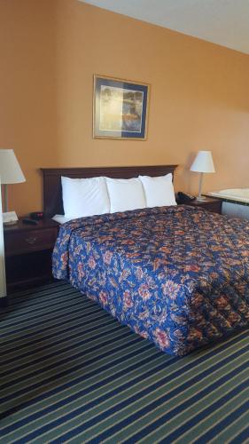 a hotel room with a bed and two lamps at The Rutledge Inn in Luverne