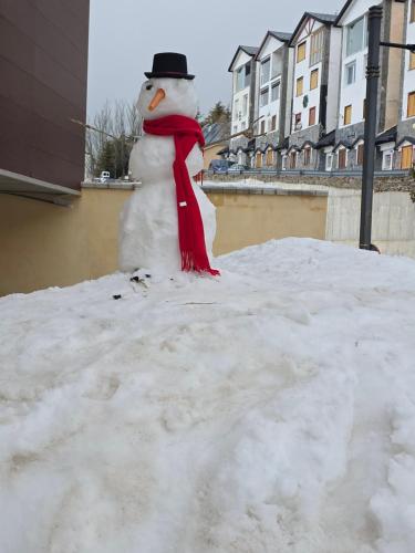 a snowman with a red scarf and hat on a pile of snow at ERASE OTRA VEZ en sierra nevada in Sierra Nevada