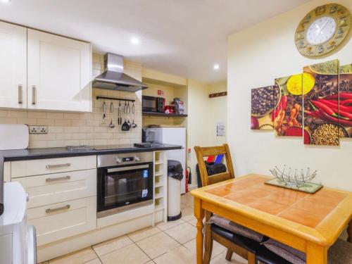 a kitchen with a wooden table and a dining room at Plas Bach in Haverfordwest