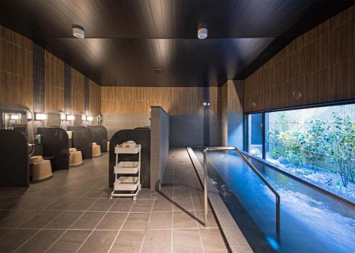 a bathroom with a swimming pool next to a swimming pool at Hotel Route Inn Higashi Matsue-Higashi Izumo Inter- in Matsue