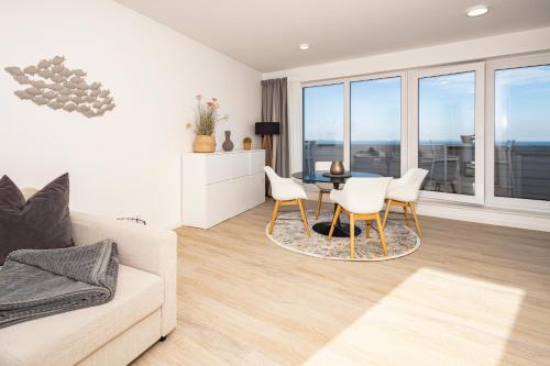 a living room with a couch and a table and chairs at Ostsee Suite 1 - Strandperle in Niendorf