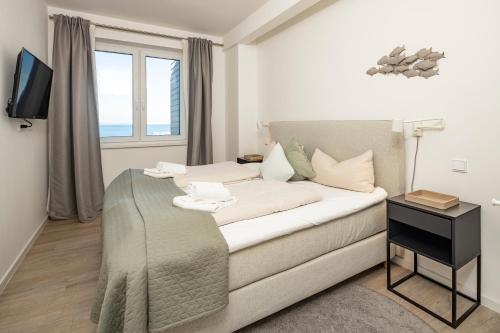 a living room with a bed and a window at Ostsee Suite 1 - Strandperle in Niendorf