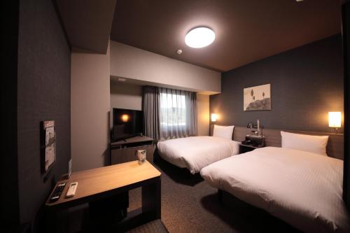 a hotel room with two beds and a table at Hotel Route Inn Higashi Matsue-Higashi Izumo Inter- in Matsue