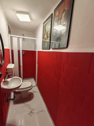 a red bathroom with a toilet and a sink at L'Amplesso xxx in Bari