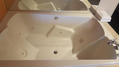 a white bath tub with a sink in a bathroom at The Rutledge Inn in Luverne