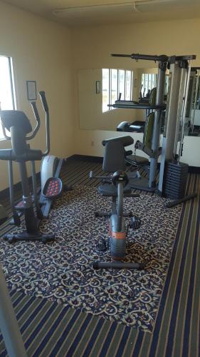 a gym with several treadmills and chairs in a room at The Rutledge Inn in Luverne