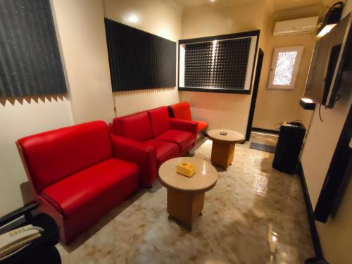 a living room with a red couch and a table at Dago Hotel Salon FORA in Bandung